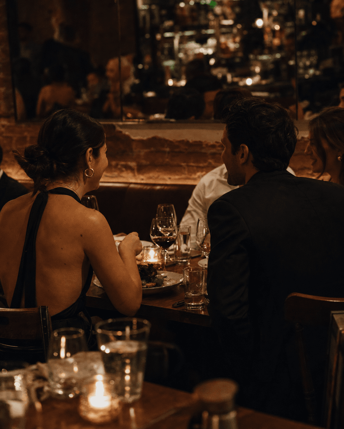 Guests sharing dinner in the evening glow at a lively New York restaurant